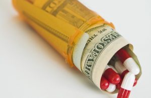 Money and pills in medicine bottle
